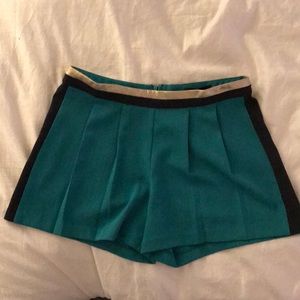 Pleated green shirts with navy and gold trim